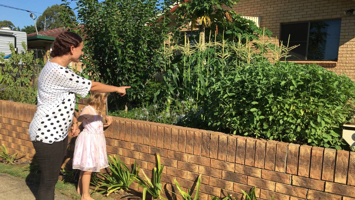 LOOK MUM: Cassie Garland and daughter Emily check out what's growing in Jill Nixon's garden.